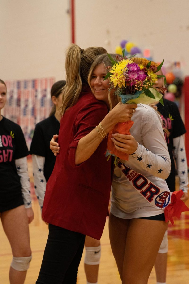 Coach Veronica Kirkpatrick shares a hug with Alanna Orton (12).