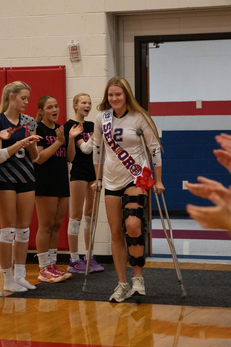Ashlyn Stafford (12) walks down the tunnel of teammates on crutches after tearing her ACL.