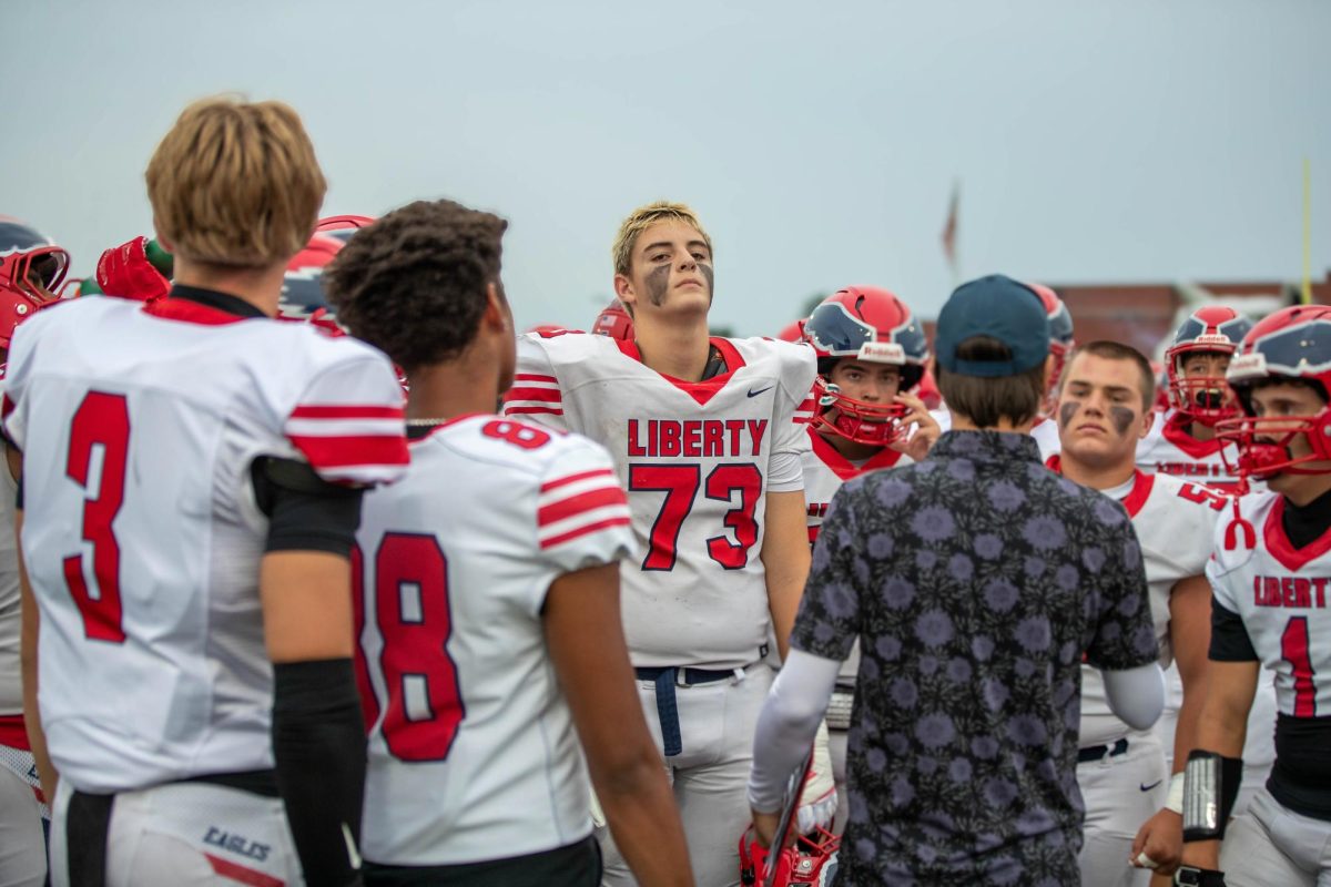 Van Kozlowski and the team listening while their coach gives them the Game plays.