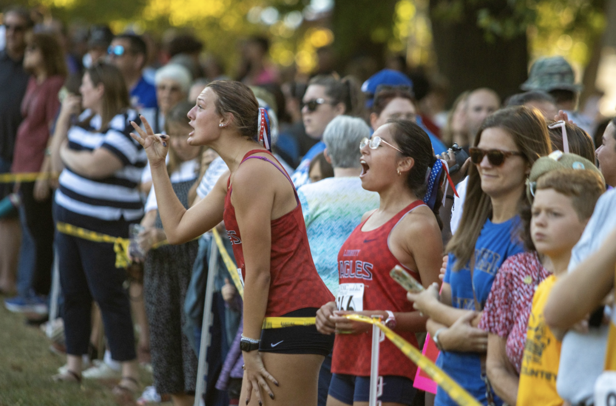 Mary-Jane Fleming (12) and Bella Navarro-Sanchez (11) cheer on their teammates as they race. 