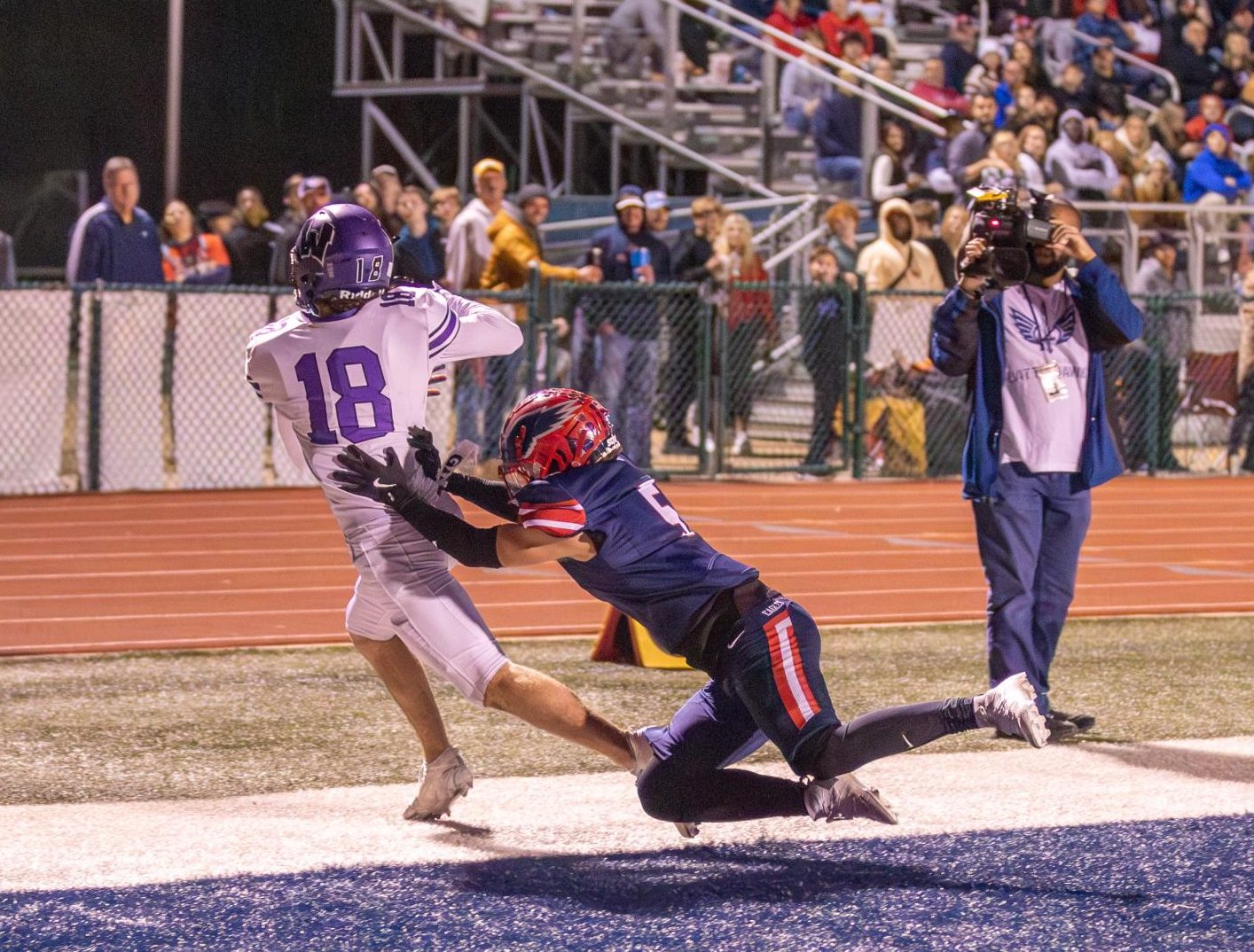 Reece Klein (#18) of Zumwalt West hauls in a 19-yard pass while tackled by Miguel Espinosa (12). The touchdown gave West a 16-7 lead in the fourth quarter. 