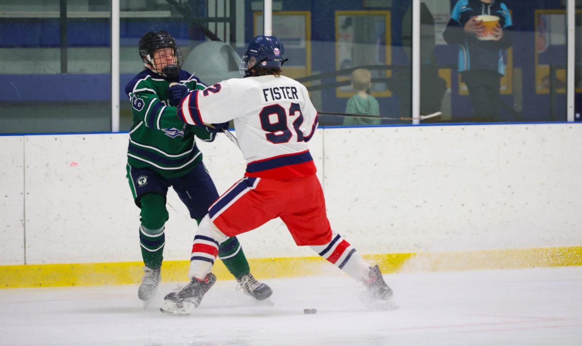 Kyle Fister (9) comes to a stop as he cross checks Timberland player.