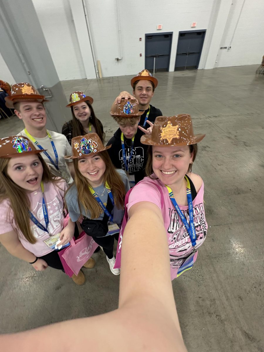 Publications students pose with their cowboy hats from Varsity Yearbook while at the trade show.