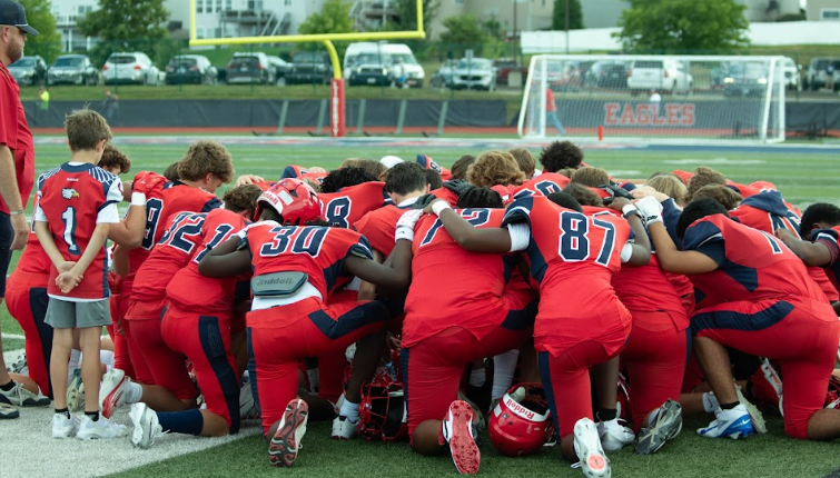 Colson Conley (9) leads the freshman team in prayer before the game.  
