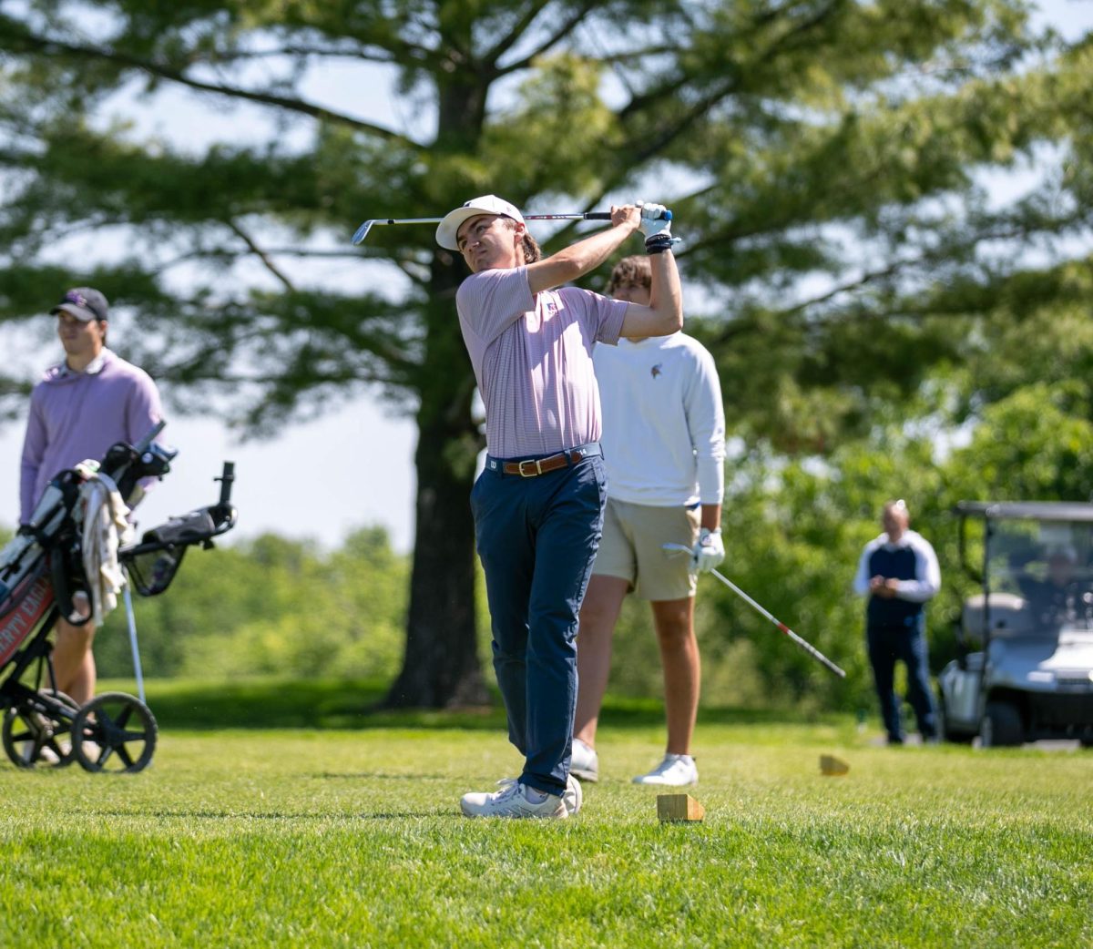 Cole Packingham (12) watches the ball fly after he hits the ball.