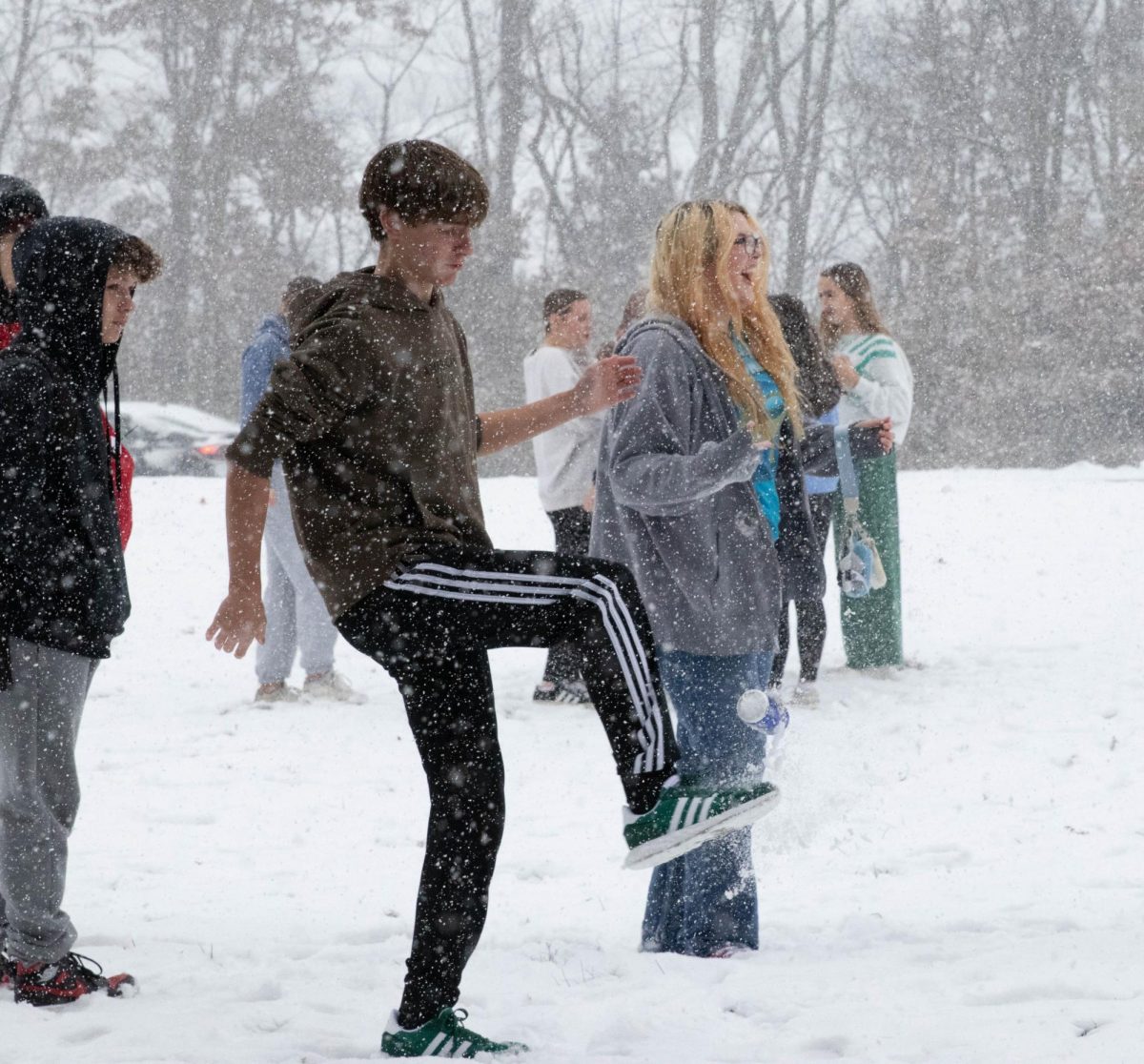 Carson Bell (9) kicks a soda can in the snow.