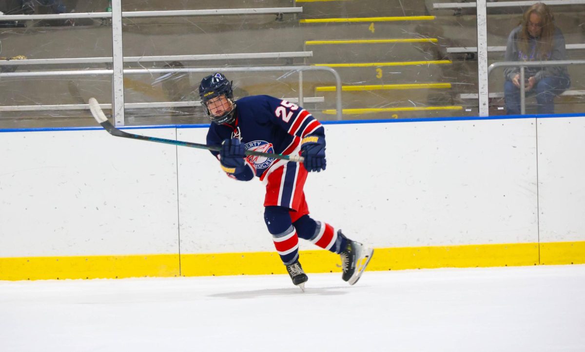 Diana Kemp (12) looks across the ice after passing the puck against Seckman.