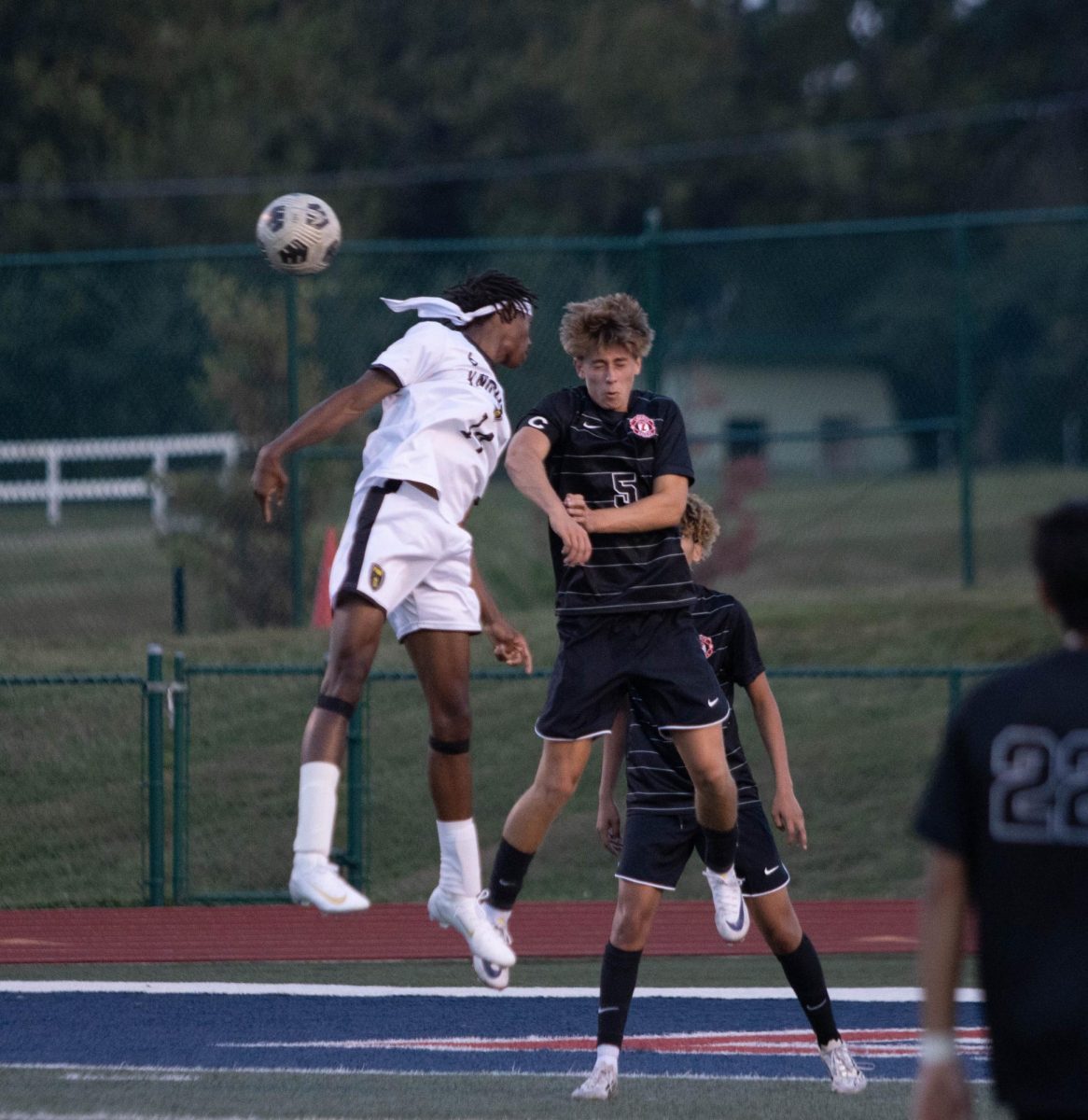 Captain of the varsity soccer team, Jackson Rocco (12) jumps with an opponent to gain control of the ball.