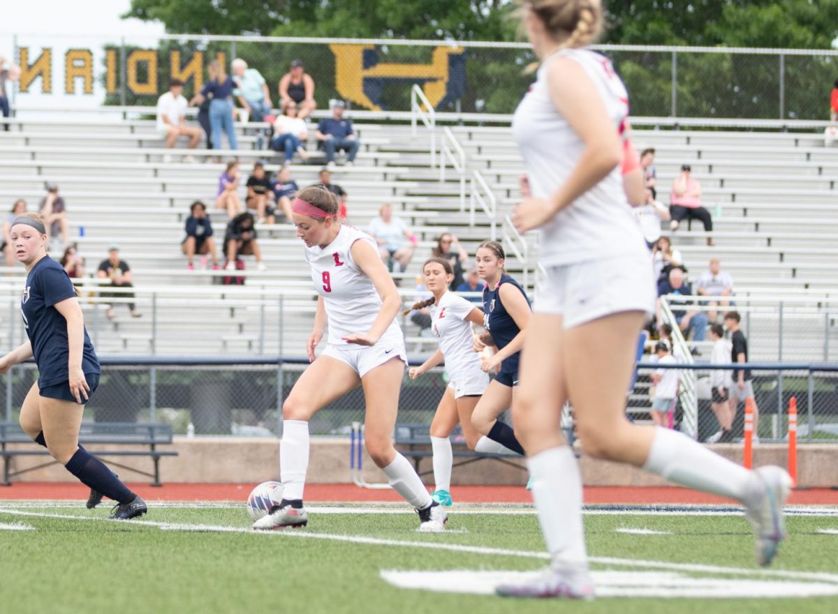 Captain Annie Swift (12) dribbles through opponents towards the goal.