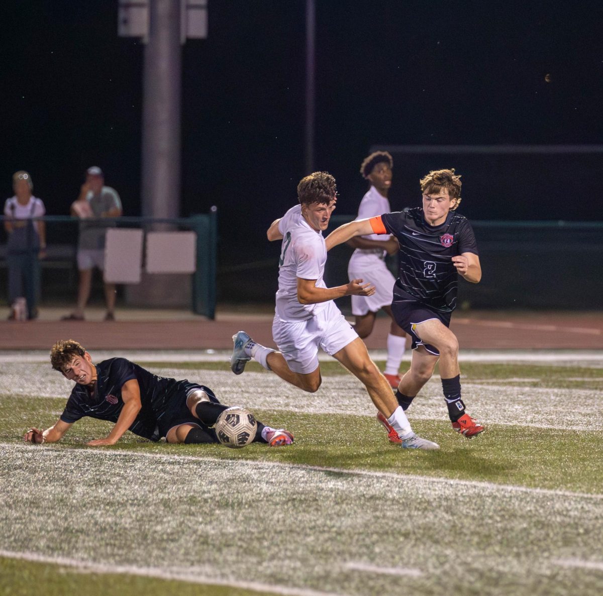Gavin Moyers (12) slides under Rock Bridge opponent to get the ball.