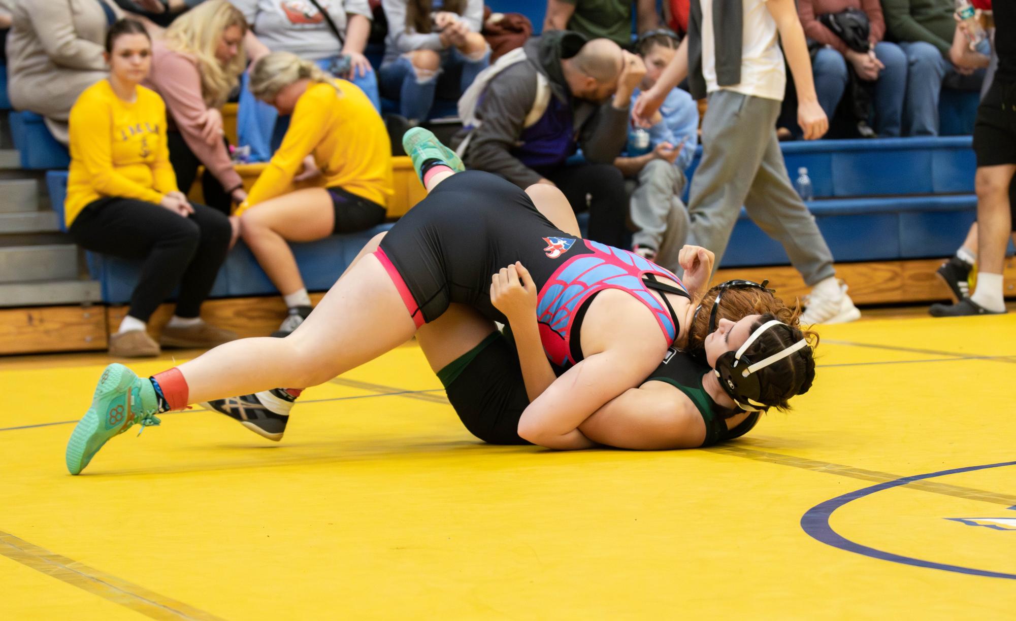 Madilyn Headley (10) attempts to pin her opponent while wrestling on a tournament at Bolivar.