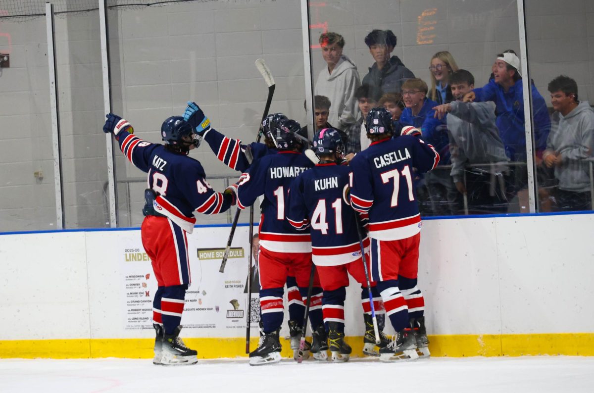 Liberty players point towards the score board in front of Seckman student section after scoring a goal.