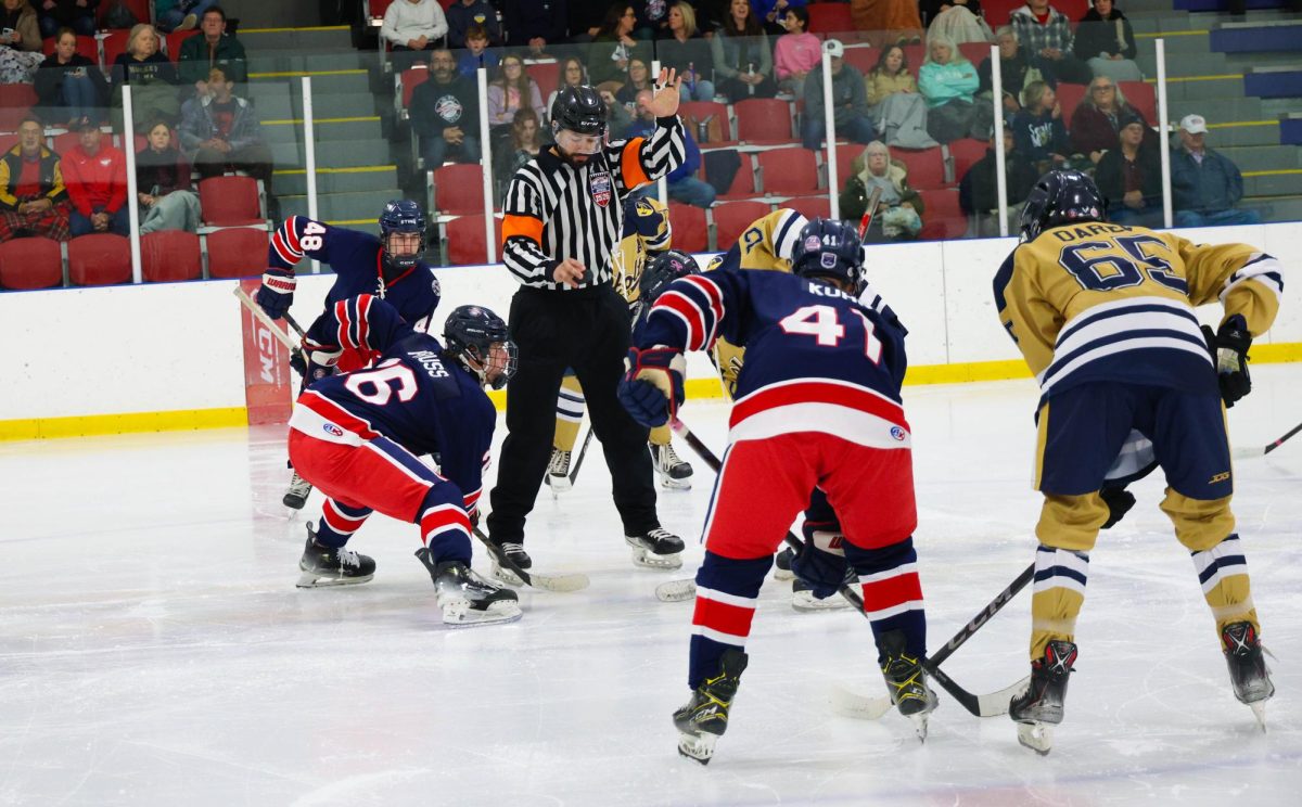 Zachary Pruss (12) leans down to take a face off against Holt.
