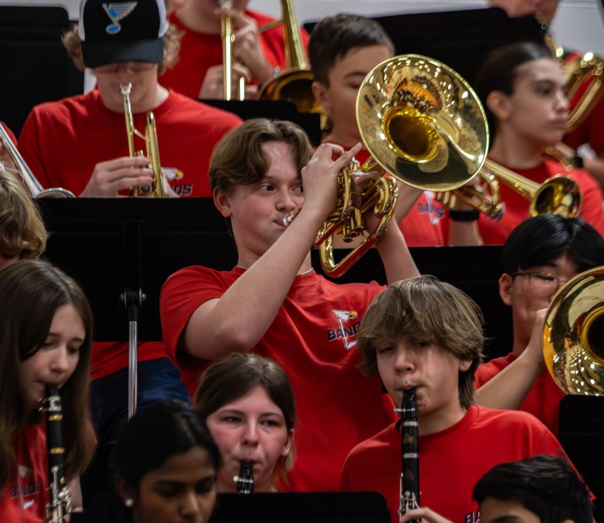 Kaiden Bax (11) plays his mellophone during a boys basketball game.