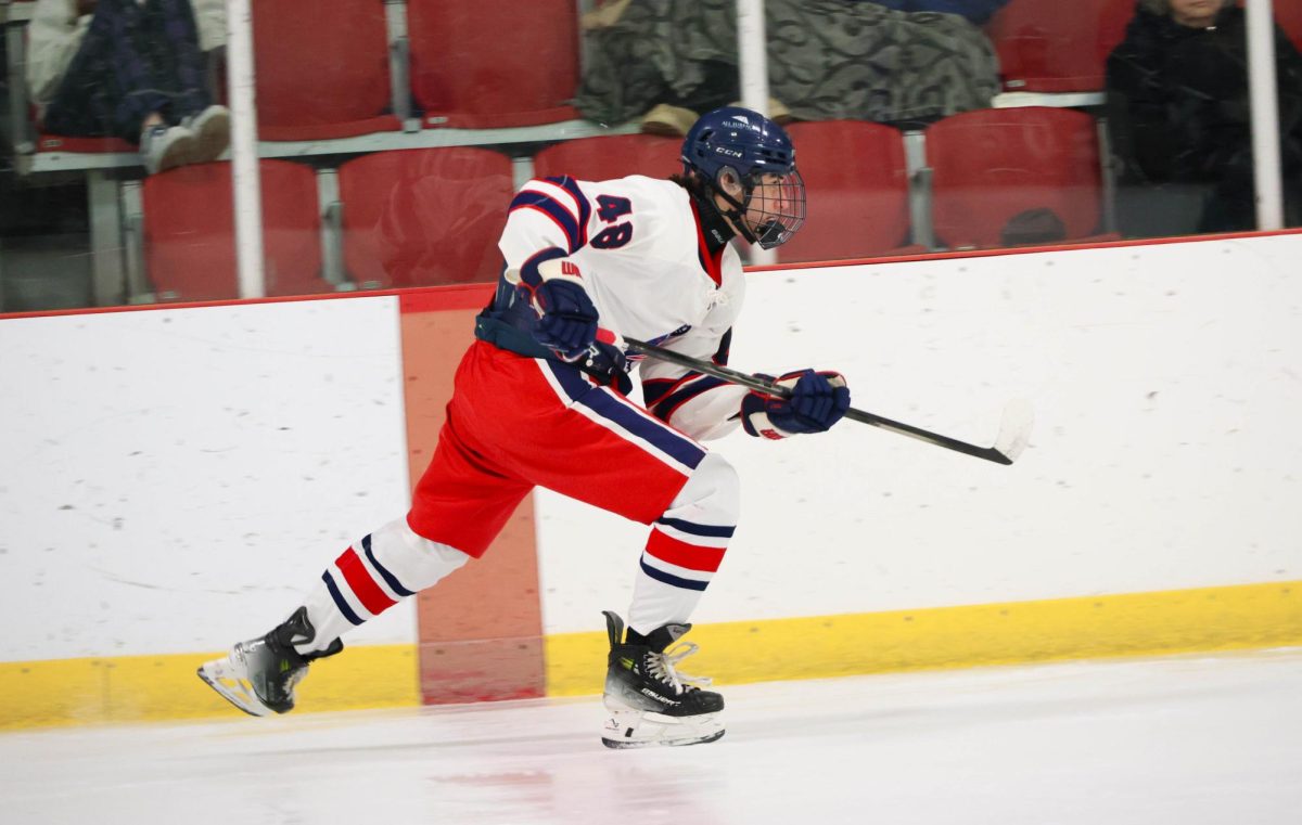 Garrett Katz (11) skates down the ice towards the puck against Francis Howell Central.
