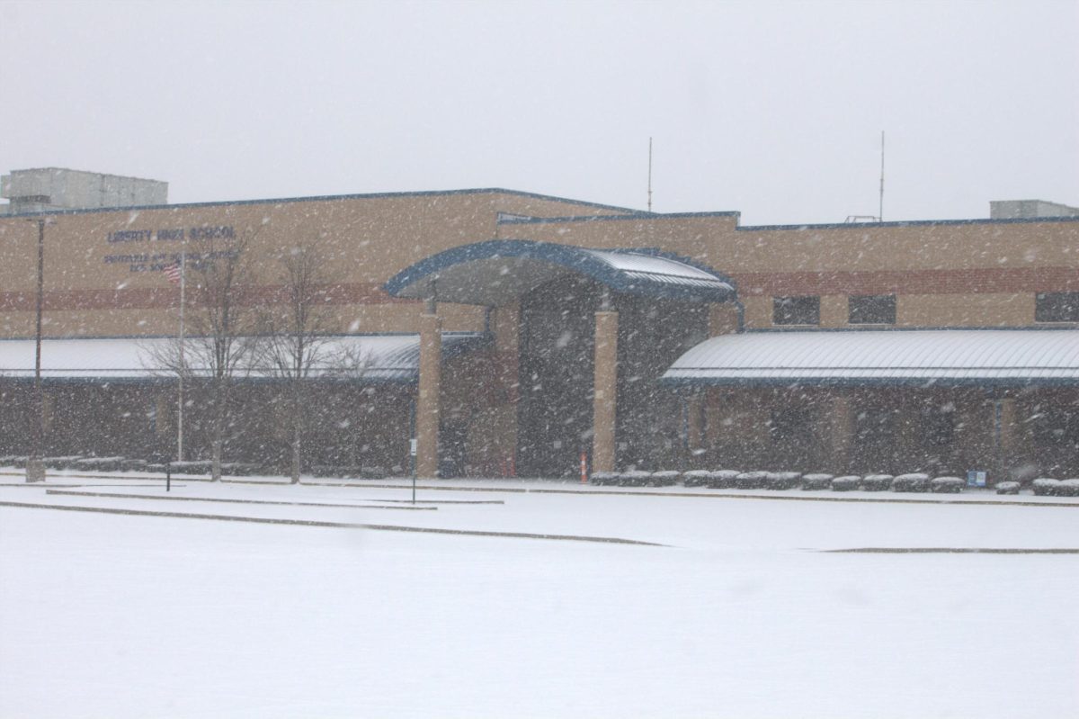 Snow falls in front of Liberty High School over the weekend. 