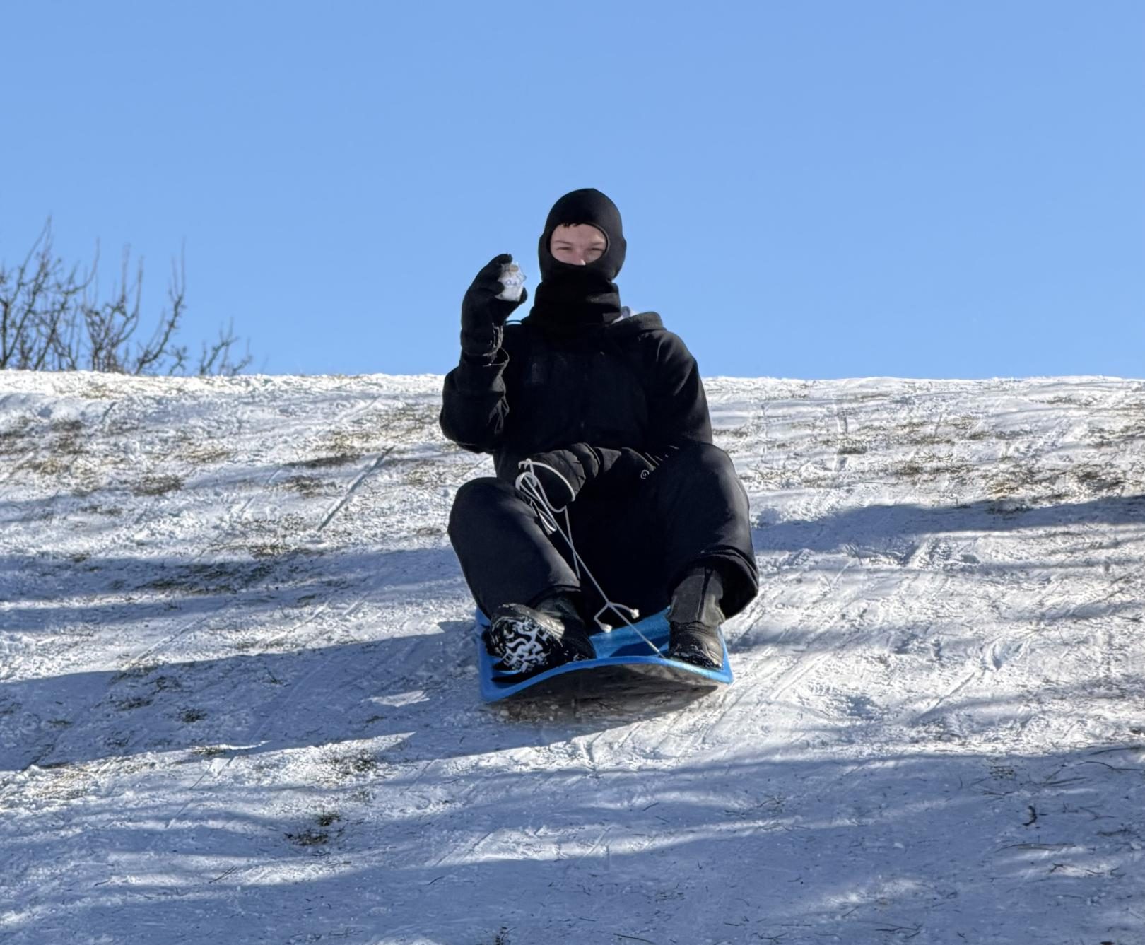 Zach Geisler (12) sleds down a snowy hill along with his egg.
