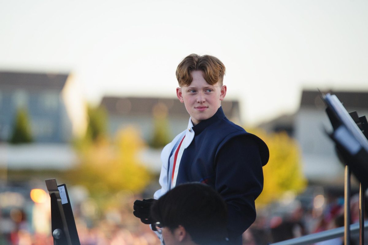 Kaiden Bax (11) sits in the stands during a football game.