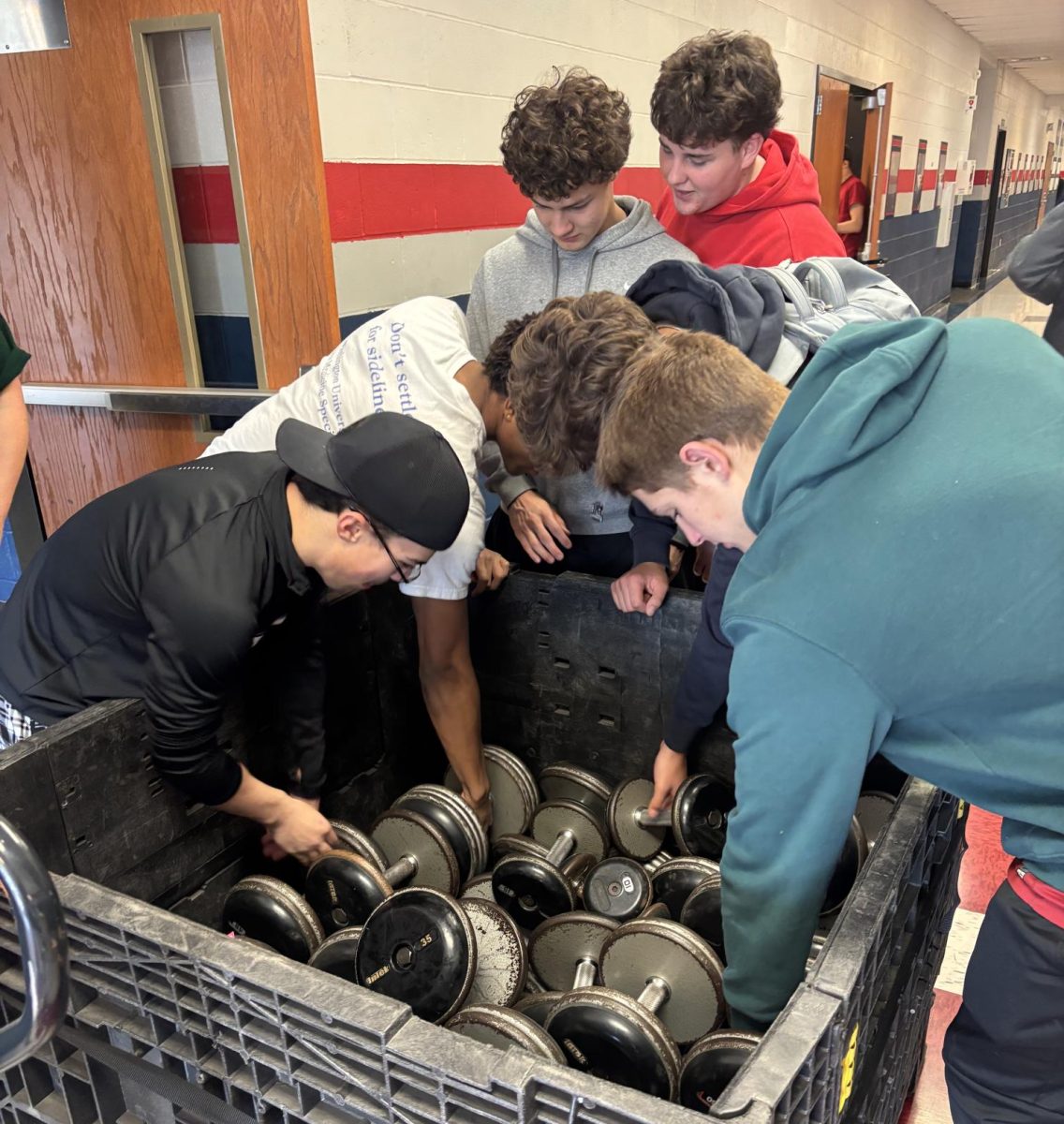 Students grab the new weights purchased from the fundraiser and help put them away.