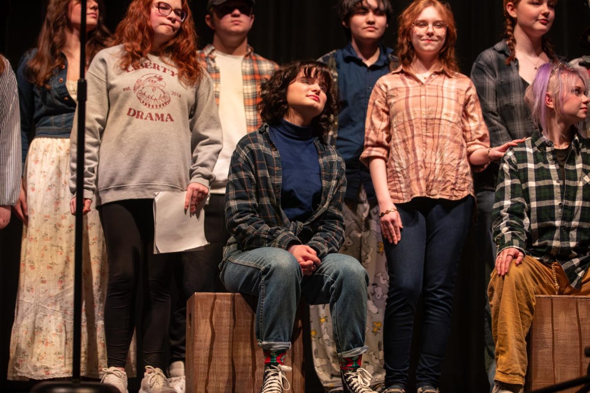 Micki Morris (12) sits with the cast as they open the talent show with the song "Oklahoma"; a song they have been learning since the earliest rehearsals.