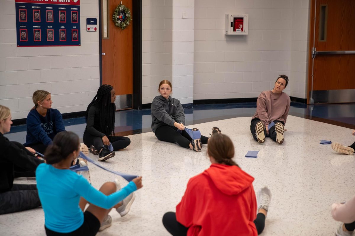 Coach Dukeman does stretches with the track girls. 