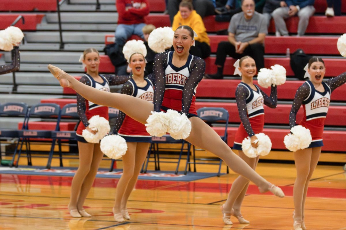 Embree Gruettemeyer (10) prepares to jump mid-skill during the pom routine.