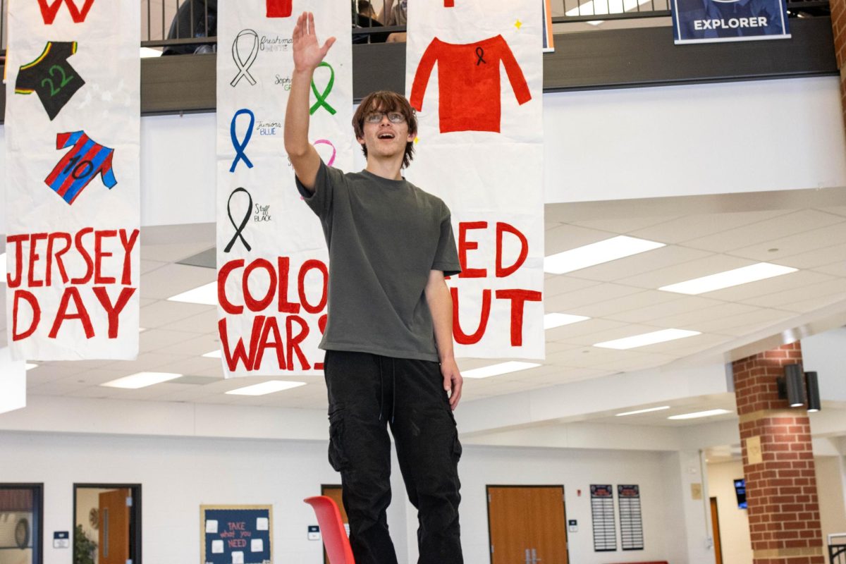 Carson Bell (9) posed in cafeteria by Spirit Week Signs.