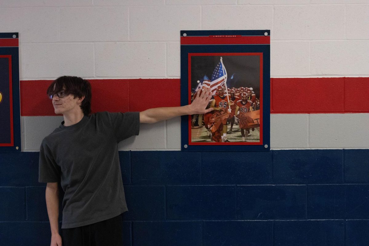 Carson Bell (9) by American flag held by football team