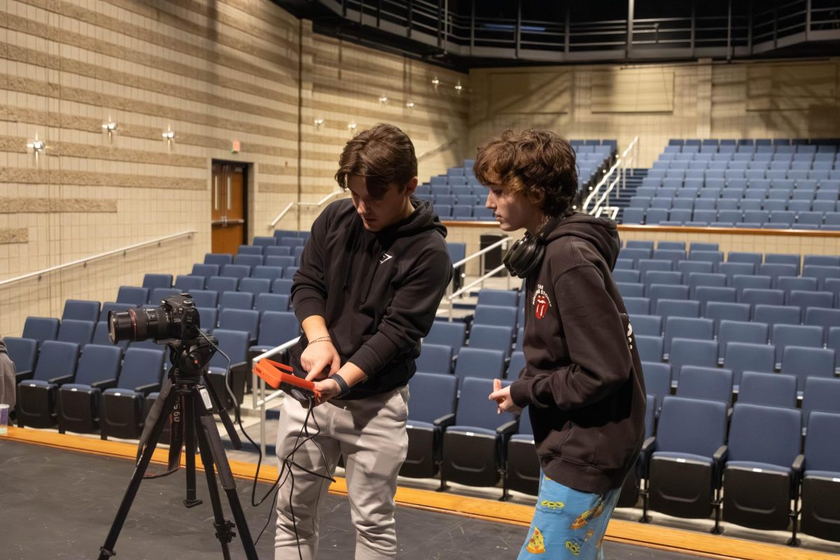 Will Nolan (12) shows August Deters (10) their job of candidate camera person for The Student's Town Hall.