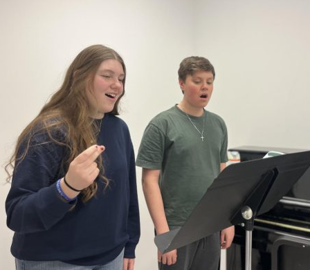 Choir students Ellie Force (11) and Cohen Roach (9) sing through one of the songs for their quartet.