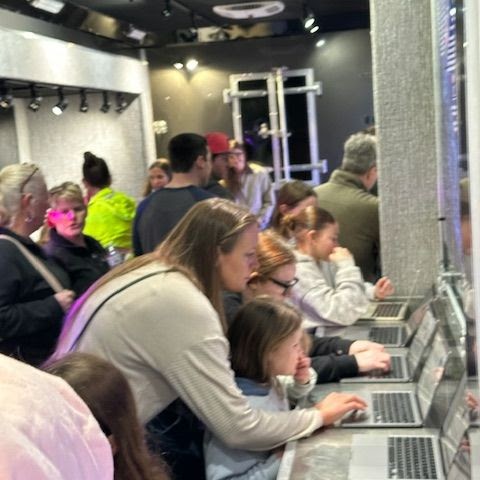 Parents and children watch the MoBIO Lab trailer at the science fair.