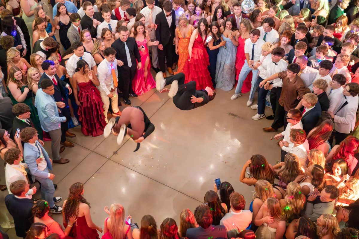 Two students do a flip in the middle of the dance circle.