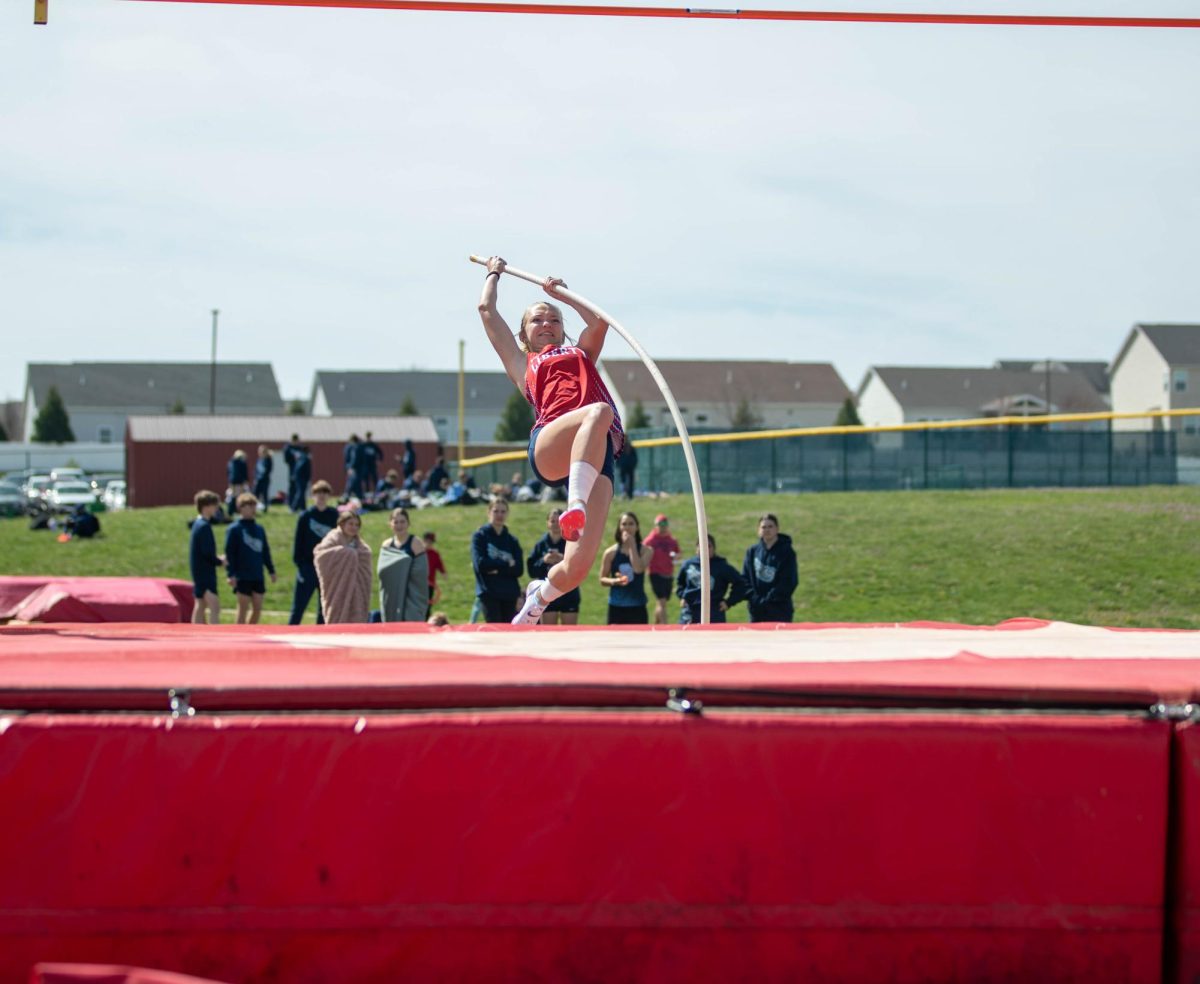 Piper Wietbrock (10) runs and jumps with her pole to attempt and get over the bar. 