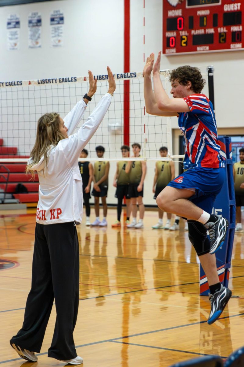 During starting lineup, Brody Breen (11) shares and high-five with head coach Veronica Kirkpatrick.