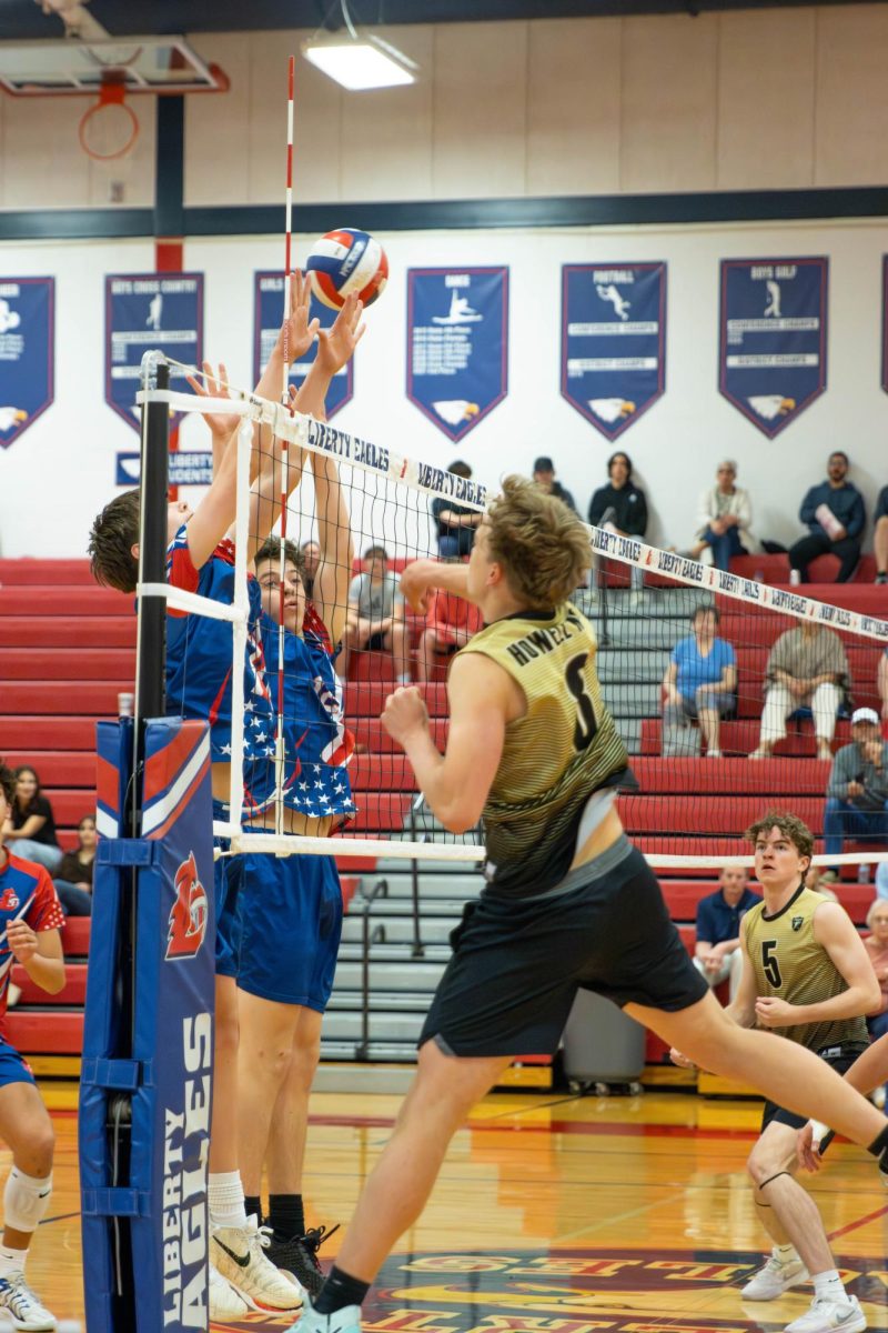 William Quinney (10) and Beckham Laboube (9) block the other team from hitting the ball over the net.
