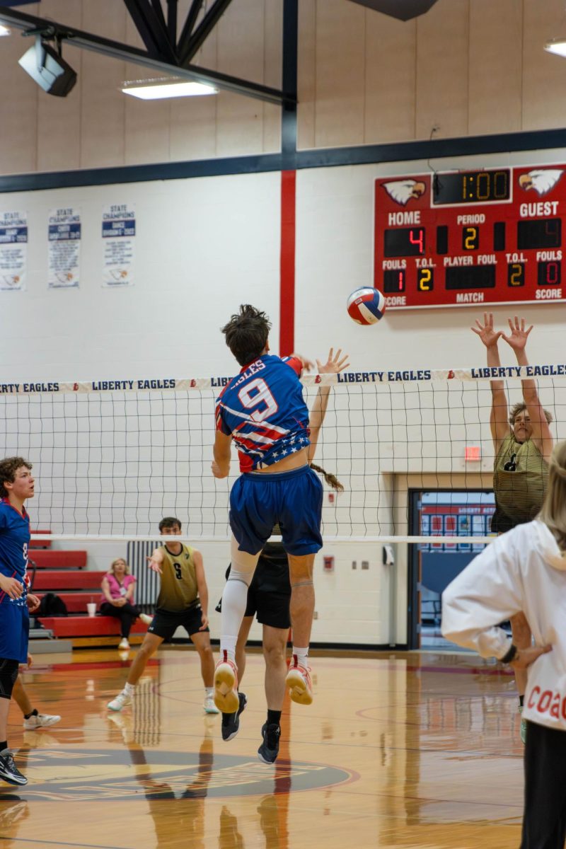 Brody Breen (11) hits from middle position through the block scoring.