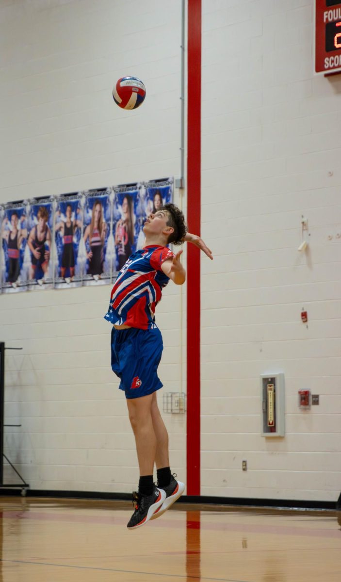 William Quinney (10) serves the ball to the other team.