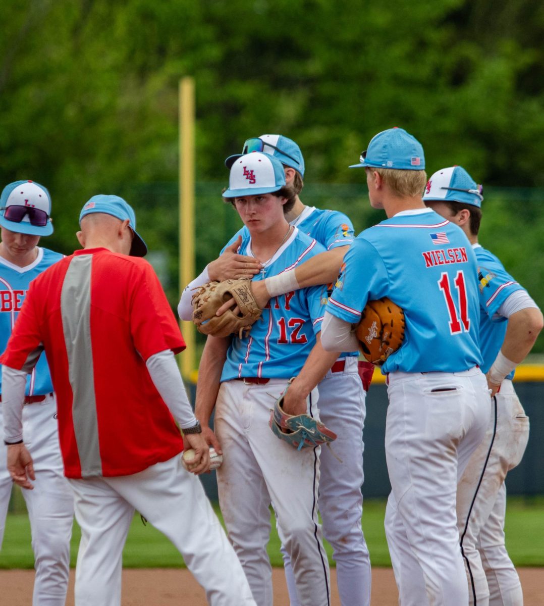 James Good (10) gets hugged by one of his teammates after the other team gets a home run.