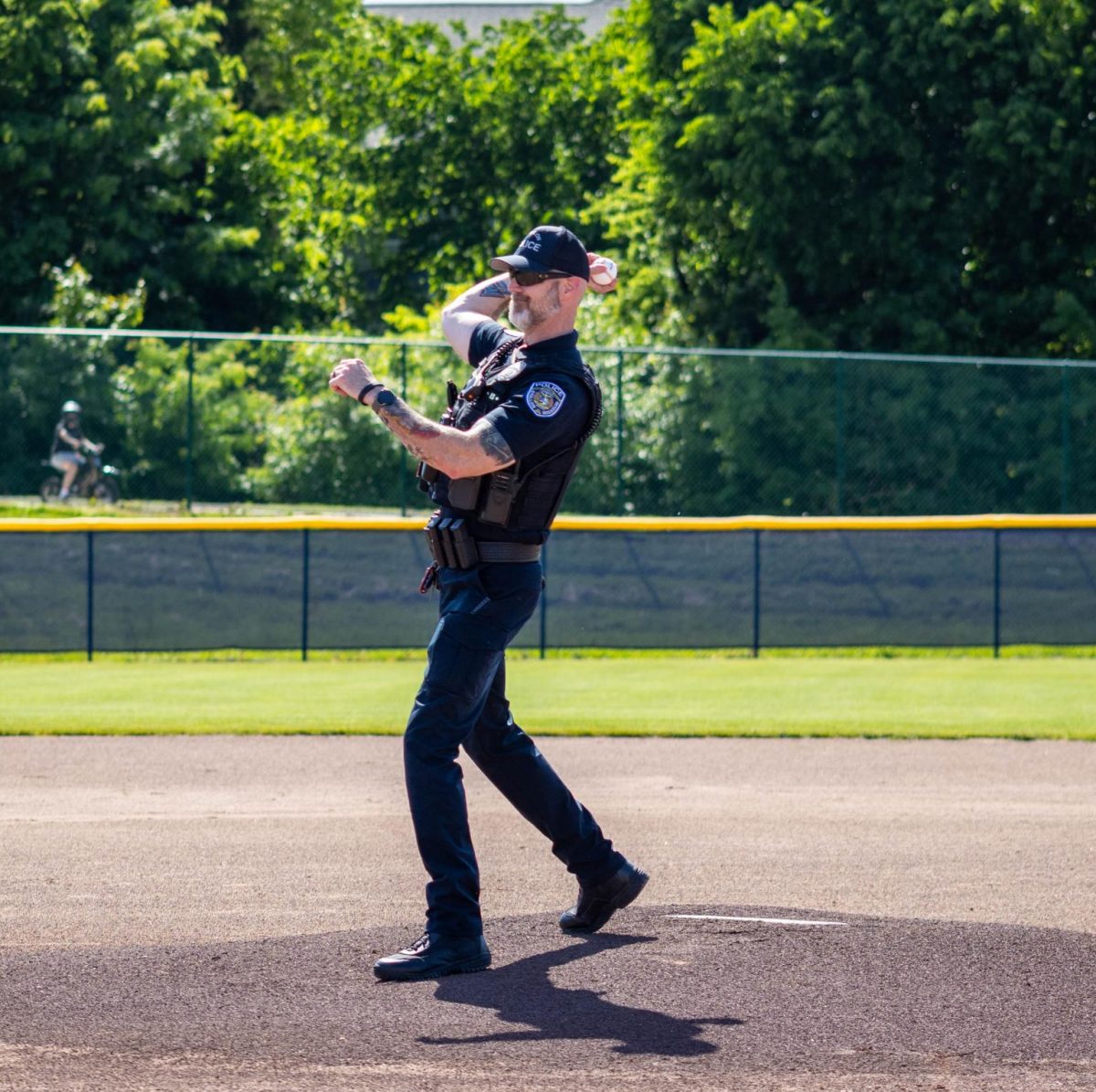 Officer Stearns throws a pitch to the catcher to start the game.