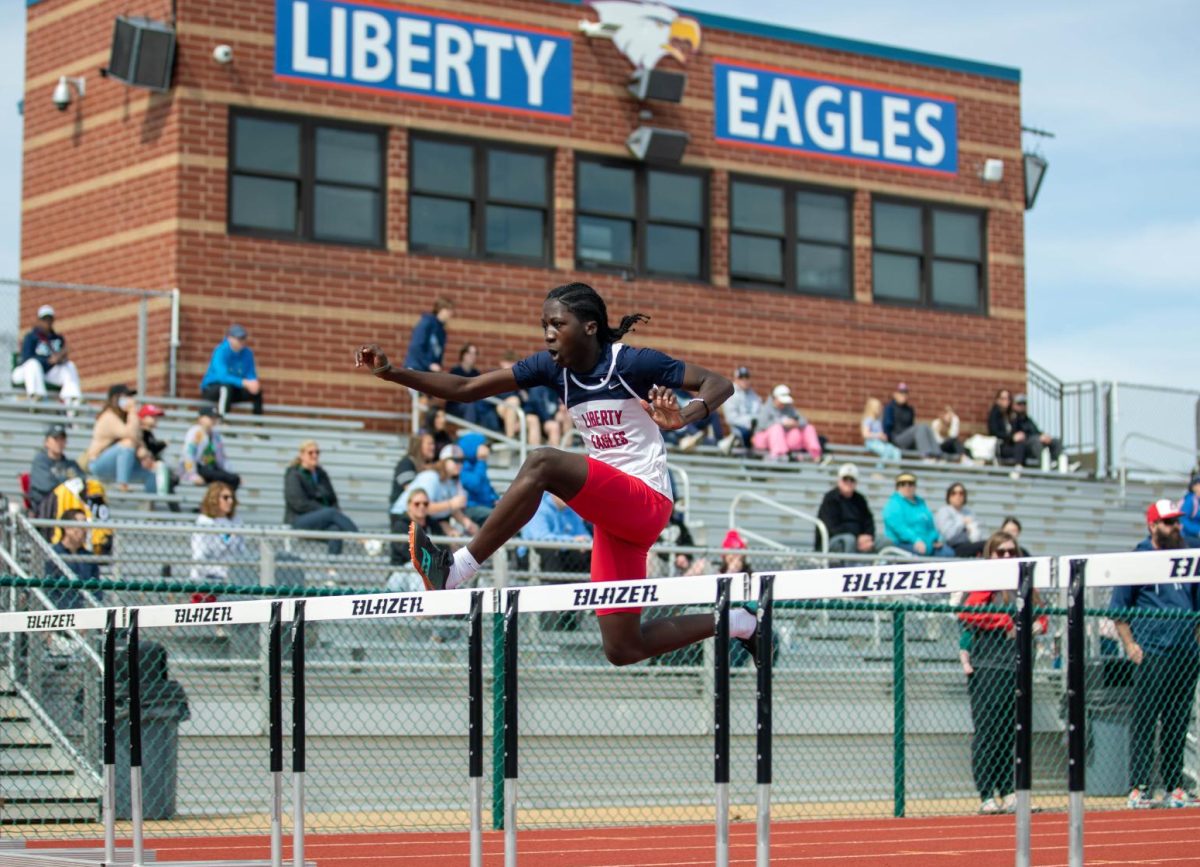 Noah Ellis (9) jumps over the hurdle to get to the finish line.