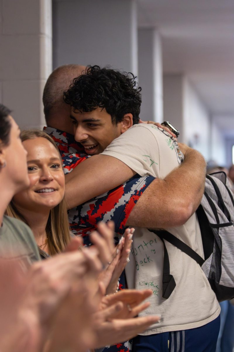 Yazan Ahmed (12) hugs Mr. Barnes while walking towards the bridge. 