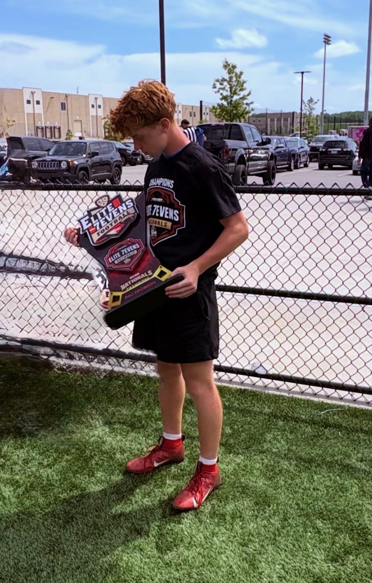 Brayden McGowen holds up the Elite7's national championship trophy. 