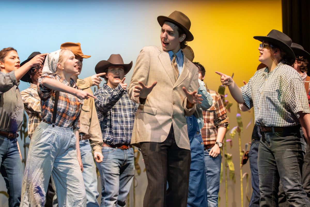 The male ensemble circles Ali Hakim, played by Sebastian Tabers (12), as they sing "It's a Scandal." Tabers worked with director Melissa Gehrke to develop a Brooklyn accent for the character.