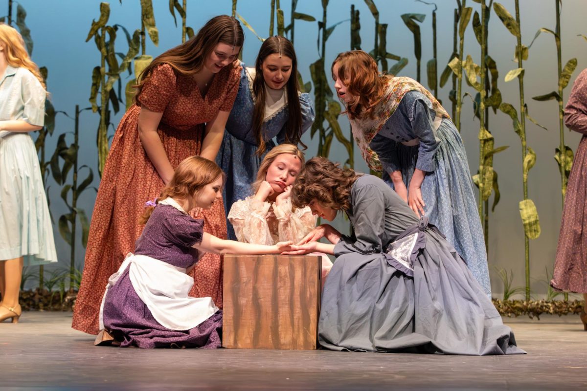 Lauren Fereday (9) reads Noelle Wise's (12) palm while the female cast eagerly watches. Each member engaged in friendly conversation before the number "Out of my Dreams" began.