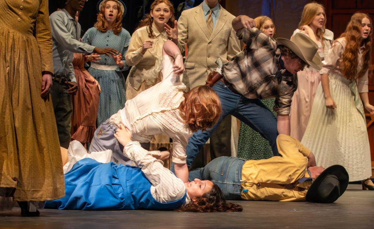 Peyton Bemis (9) holds her fist above a terrified Nancy Badwan (9), while Tyler Bugg (12) aims for Samuel Varga (10) behind them. The song "The Farmer and the Cowman" featured a thrilling brawl between the two types of Oklahoma residents.