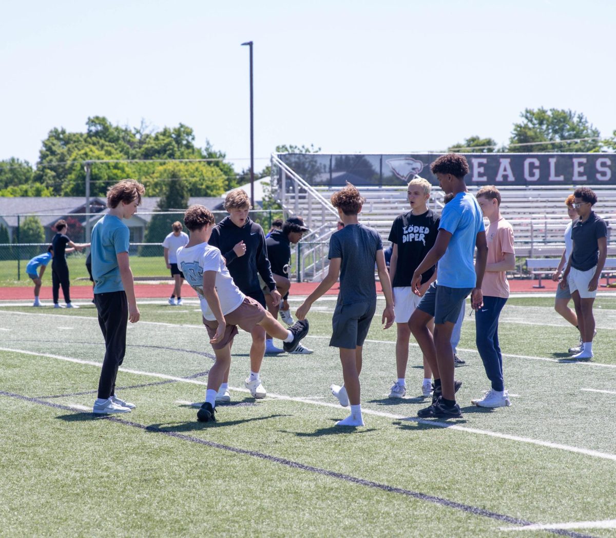 A group of boys participate in a game of hacky sack during lunch.