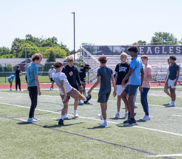 A group of boys participate in a game of hacky sack during lunch.
