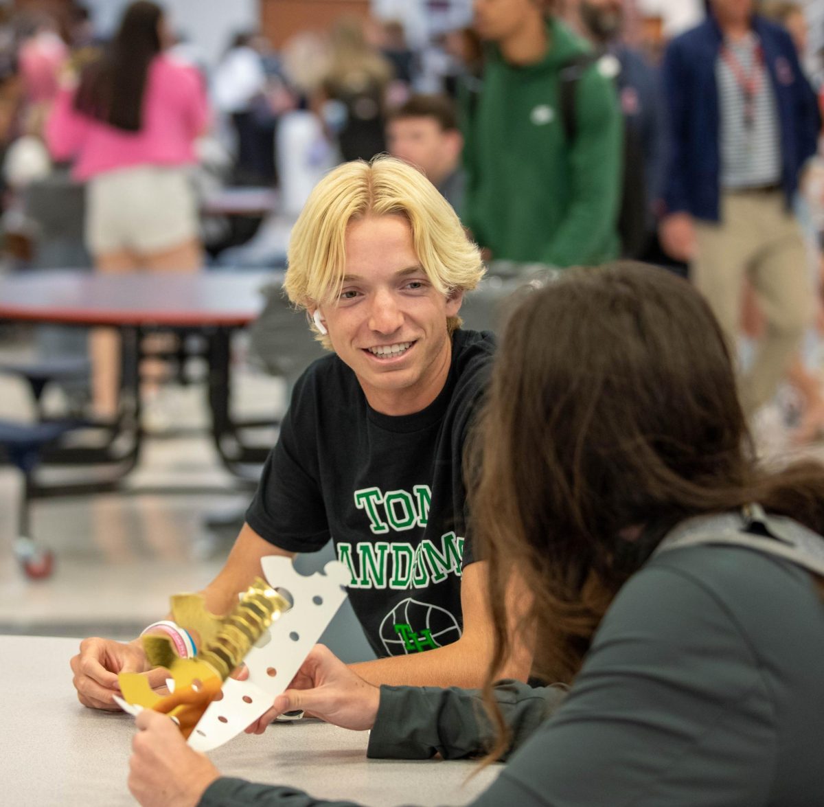 Nate Wietbrock (12) talks to a friend while signing his crown.