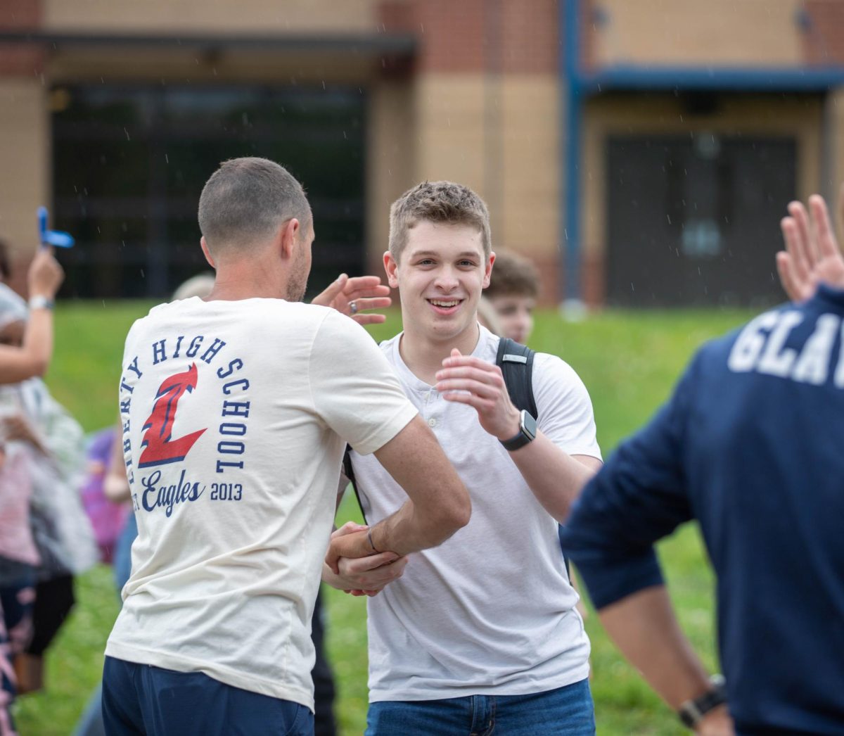 Mason Moilter (12) hugs Coach Sodemann as he walks on the bridge.