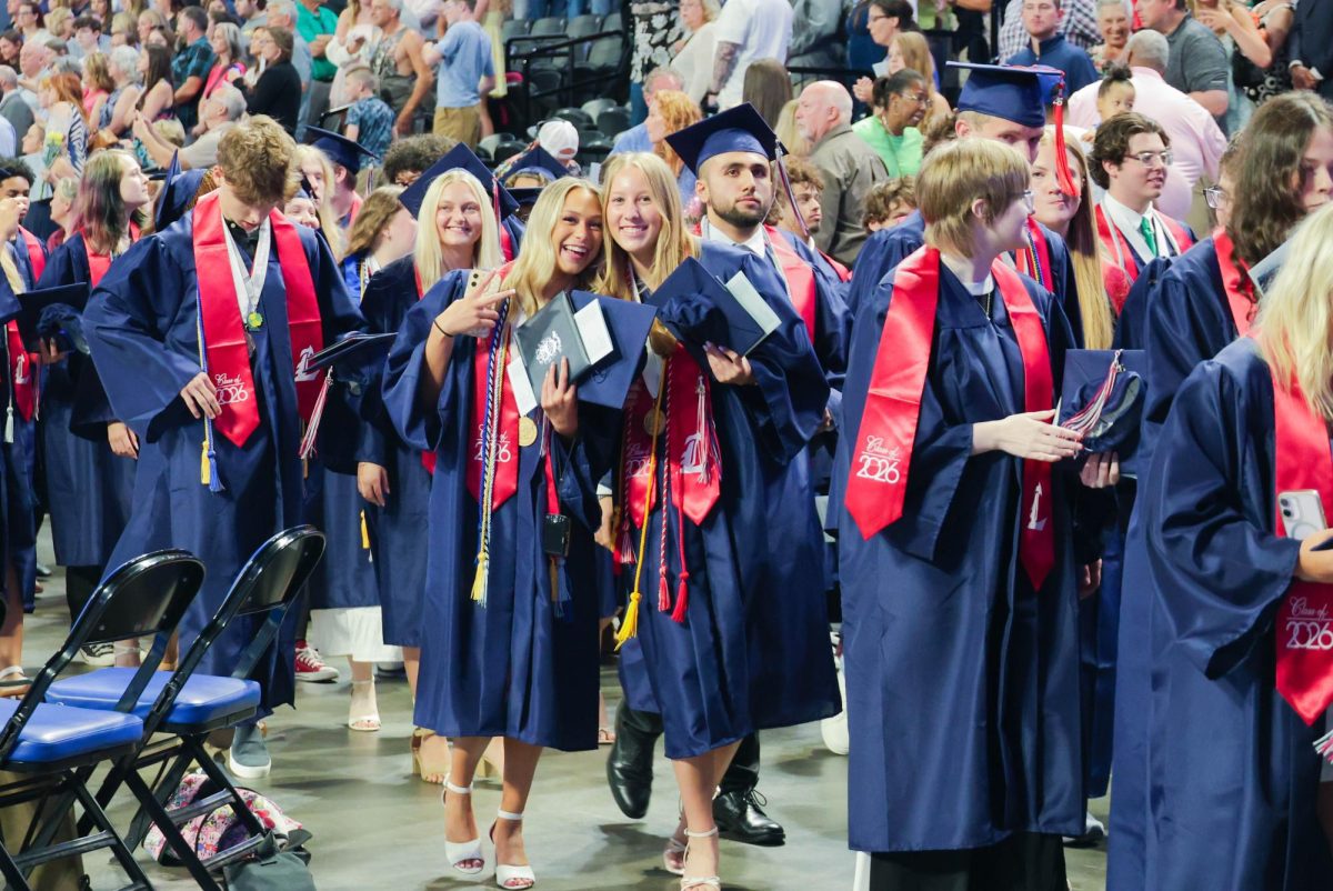 Anna Reidy and Lynleigh Hillgartner pose as they walk out after graduating.